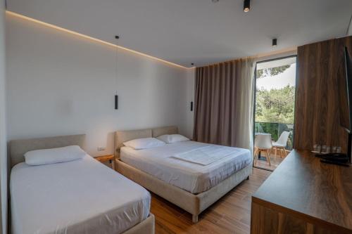 a hotel room with two beds and a balcony at Hotel Havana in Sarandë