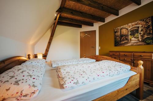 Schlafzimmer mit einem Holzbett mit weißer Bettwäsche in der Unterkunft Ferienwohnung Olaf in Schneverdingen