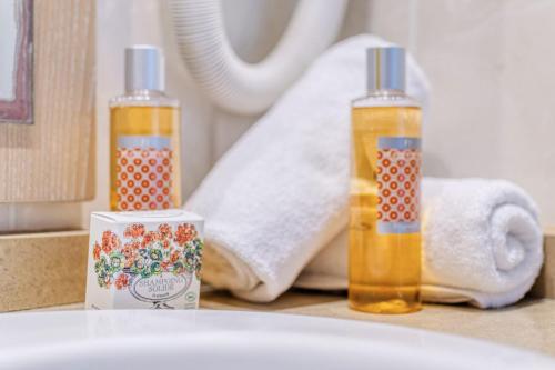 deux bouteilles de liquide orange assises sur un comptoir de salle de bains dans l'établissement L'Excel Canne's - 3 pièces Cannes, à Cannes