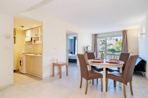 une cuisine et une salle à manger avec une table et des chaises dans l'établissement L'Excel Canne's - 3 pièces Cannes, à Cannes