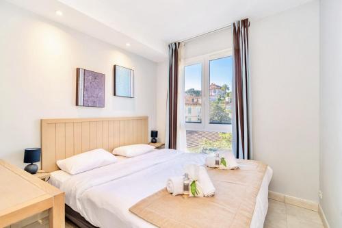 une chambre avec deux lits et une fenêtre dans l'établissement L'Excel Canne's - 3 pièces Cannes, à Cannes