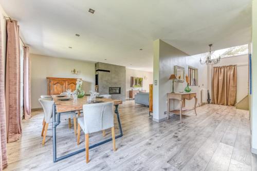 une salle à manger et un salon avec une table et des chaises dans l'établissement Maison des Platanes - Welkeys, à Lissieu