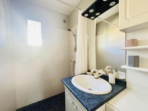 une salle de bain avec un lavabo et un miroir dans l'établissement Villa Petit Juas - Au coeur de Cannes - 4 chambres, à Cannes