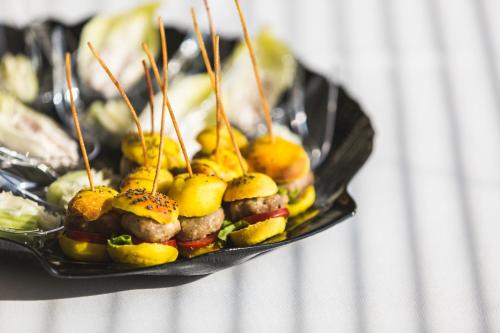 a plate of food with meatballs and fruit on skewers at JO Hotel in Marano Lagunare