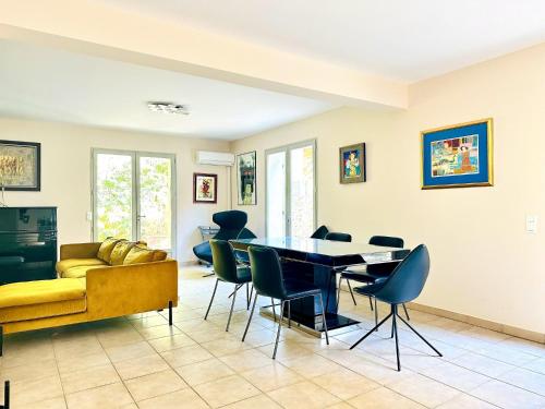 un salon avec une table et des chaises dans l'établissement Villa Petit Juas - Au coeur de Cannes - 4 chambres, à Cannes