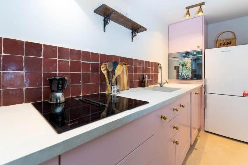 cocina con fregadero y nevera blanca en Lovely Flat Ensuite Bathroom Private Courtyard en Brighton & Hove
