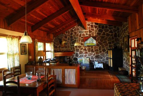 a living room with a table and a stone wall at Casa Nora Malinalco - Entire Estate With pool in Malinalco