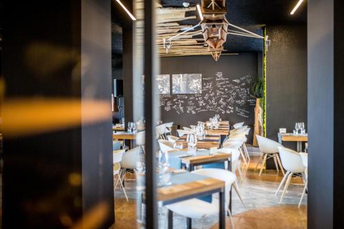 a dining room with tables and chairs and a chalkboard at JO Hotel in Marano Lagunare