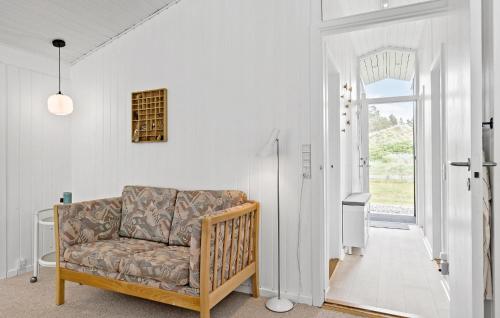 a living room with a couch and an open door at 4 Bedroom Beautiful Home In Blokhus in Blokhus