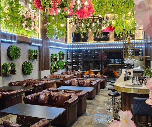 a restaurant with couches and tables and flowers at XQ Pattaya Hotel in Pattaya