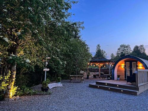 a garden with a gazebo and a wooden deck at Loch Ness Pods, Pod 2 in Fort Augustus