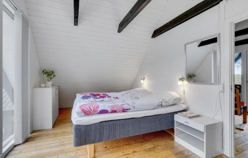 Bett in einem Zimmer mit weißen Wänden und Holzböden in der Unterkunft Beautiful Home In Hadsund With Kitchen in Hadsund