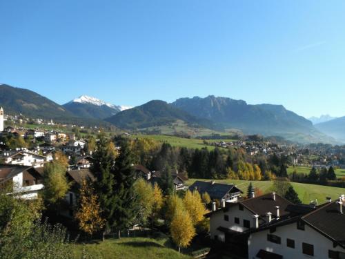 a small town with mountains in the background at Pozza Appartamenti in Carano