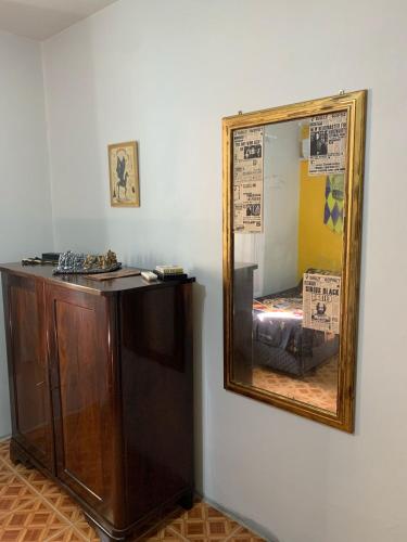 un miroir sur un mur à côté d'une commode en bois dans l'établissement Aconchego do Harry Potter, à Pomerode