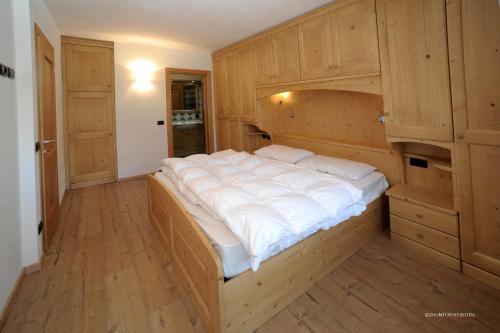 a large bed in a room with wooden cabinets at Appartamenti da Nica e Diego in Borca di Cadore