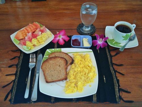 een dienblad met ontbijtproducten zoals toast, eieren en fruit bij Villa Las Brisas in Candidasa