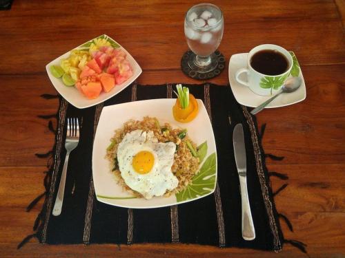 een tafel met een bord ontbijtproducten en een kopje koffie bij Villa Las Brisas in Candidasa