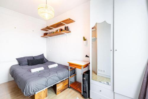 een kleine slaapkamer met een bed en een bureau bij GuestReady - Stylish Hideaway near Bercy Parc in Parijs