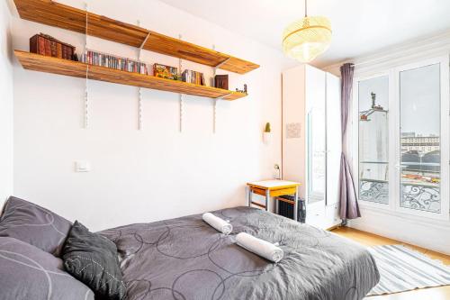 een slaapkamer met een bed en een groot raam bij GuestReady - Stylish Hideaway near Bercy Parc in Parijs