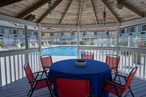 a patio with a table and chairs and a pool at Admiralty Inn & Suites - a Red Collection Hotel in Falmouth