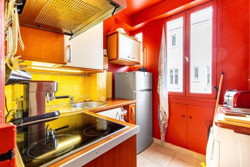 une cuisine avec un évier et un réfrigérateur dans l'établissement GuestReady - Studio Élégant vous Attend!, à Paris