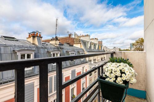 - un balcon avec un pot de fleurs sur une balustrade dans l'établissement GuestReady - Studio Élégant vous Attend!, à Paris