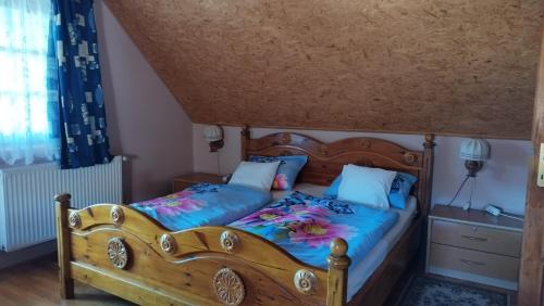 1 dormitorio con cama de madera con sábanas azules en Eszter-lak, en Monostorapáti