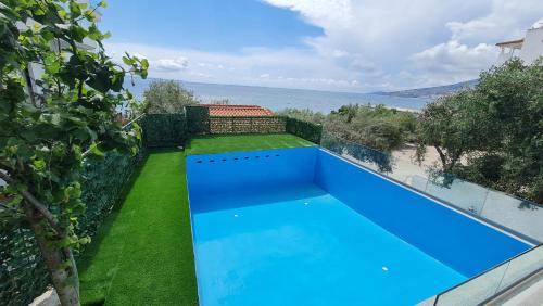 a blue swimming pool with a view of the ocean at Villa Skenderi in Sarandë