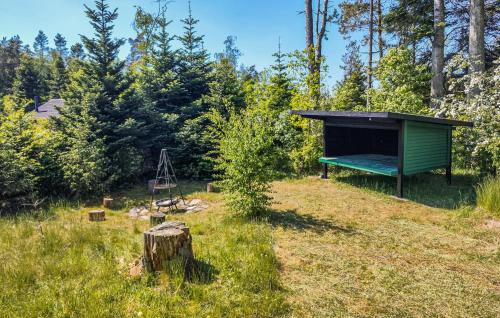 a green shed in a field with a tree stump at Gorgeous Home In Kolind With Wifi in Kolind