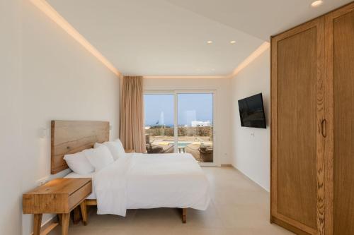 Schlafzimmer mit einem Bett und Blick auf einen Innenhof in der Unterkunft Aya Sofia Suites in Mykonos Stadt