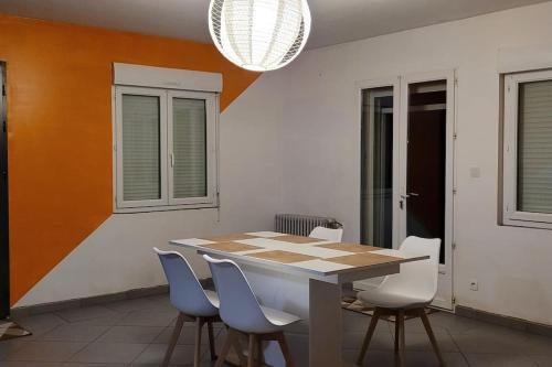 une salle à manger avec une table et des chaises dans l'établissement Maison spacieuse, à Quessigny