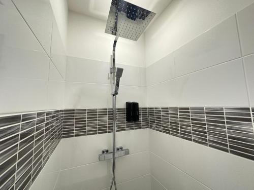 La salle de bains est pourvue d'une douche et de carrelage noir et blanc. dans l'établissement CHEZ BOB, à Limoges