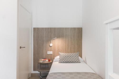 ein kleines Schlafzimmer mit einem Bett und einem Beistelltisch in der Unterkunft Apartamento Coquette a 50 metros de la playa in Platja  d'Aro