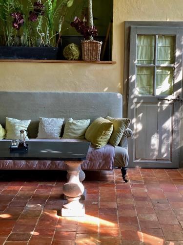 a couch with pillows sitting in front of a door at Château de Saint Paterne in Saint-Paterne