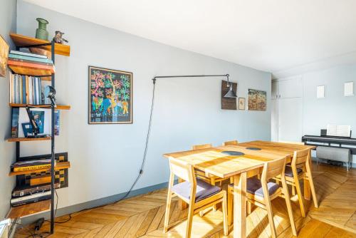 une salle à manger avec une table et des chaises en bois dans l'établissement GuestReady - Parisian Charm near Sacré-Cœur, à Paris
