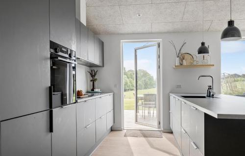 Una cocina con gabinetes blancos y una ventana grande. en Awesome Home In Haderslev With Sauna, en Haderslev