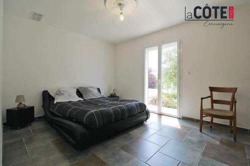 une chambre avec un lit, une chaise et une fenêtre dans l'établissement Villa Côte Bleue, à Ensuès-la-Redonne