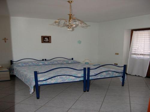 カルデードゥにあるDomus Pirasのシャンデリア付きのベッドルームの青いベッド1台