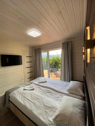 a bedroom with a large bed and a window at Kateryna in Polyana