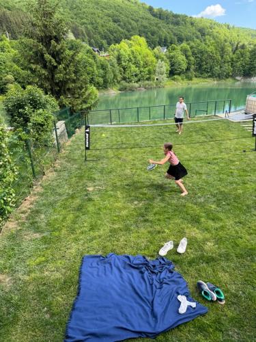 a woman playing with a frisbee on the grass at Doftana Lake House in Teşila