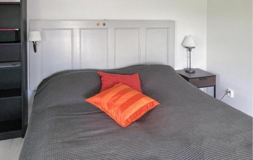 Una cama con dos almohadas naranjas encima. en Stunning Home In Sollebrunn With Kitchen en Sollebrunn