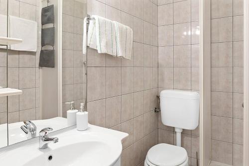 een witte badkamer met een toilet en een wastafel bij One bedroom apartement at Sibenik 500 m away from the beach with sea view furnished balcony and wifi in Šibenik
