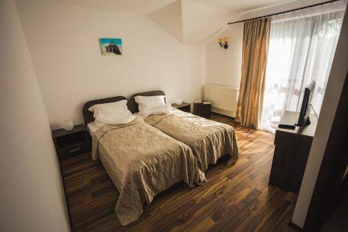 a bedroom with a bed and a large window at Casa Cu Nuc in Brebeni