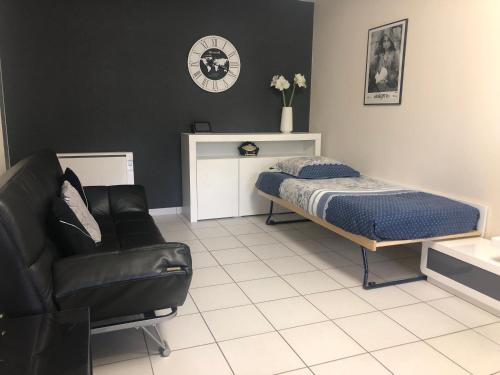 a bedroom with a bed and a couch and a chair at Appartement au calme proche centre ville in Quimper