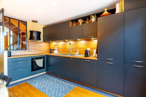 une cuisine avec des armoires bleues et un tapis bleu dans l'établissement GuestReady - A remarkable stay in Nogent-sur-Marne, à Nogent-sur-Marne