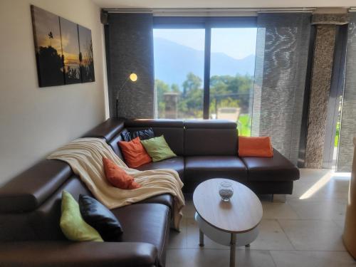 sala de estar con sofá de cuero y mesa en Casa Moorea, en Brione sopra Minusio