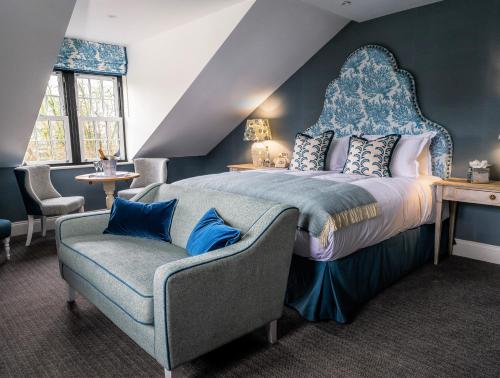 a bedroom with a large bed and a chair at The Swan Hotel and Spa in Newby Bridge