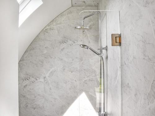 a shower in a bathroom with a marble wall at Seren in Llanddewi Ystradenny