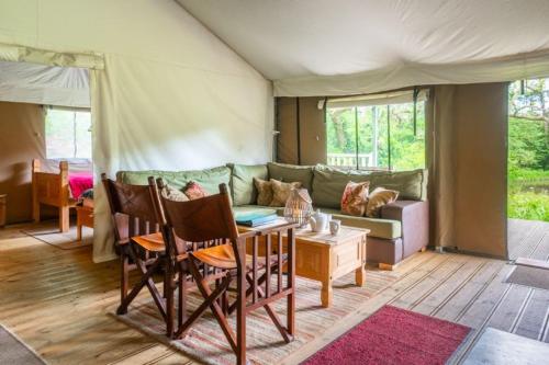 a living room with a couch in a tent at Moorhen - Exton Park in Exton