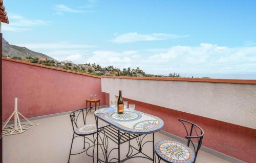 a table and chairs on a balcony with a bottle of wine at Awesome Apartment In Trabia in Trabia